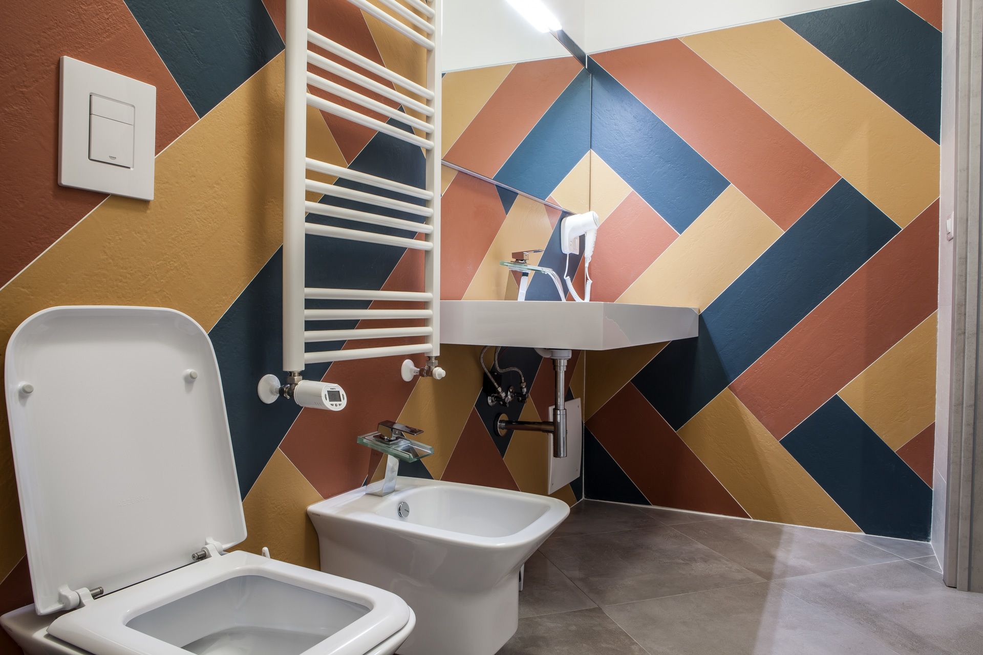 A bathroom with a toilet, bidet, and a sink with a mirror.