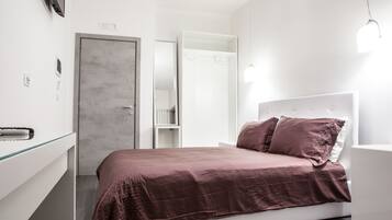 Un dormitorio moderno con una cama, un armario y una mesita de noche.
