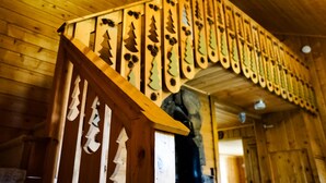 Un escalier en bois orné de motifs sculptés représentant des pins.