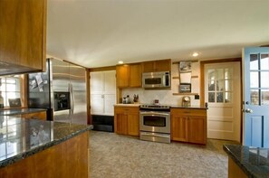 Enjoy cooking in this well-equipped kitchen with a central island, refrigerator, microwave, and oven.