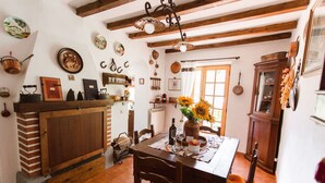 Ein rustikaler Essbereich mit Holztisch, Stühlen und einer Vase mit Sonnenblumen.