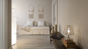 A bedroom with a bed, bedside table, lamp, and wall decor. - CP Resort (Torricella Taverne)