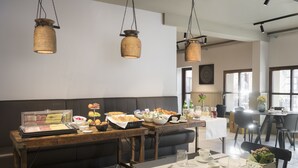 A dining area with a wooden table set for breakfast, a buffet with various food items, and hanging wooden pendant lights. - CP Resort (Torricella Taverne)