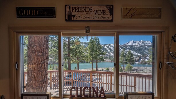 Une cuisine dotée d’une grande fenêtre donnant sur un paysage magnifique, avec des montagnes et un lac en toile de fond.