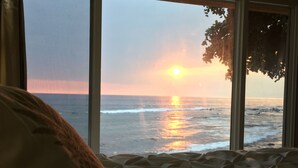 Ein Schlafzimmer mit Meerblick bei Sonnenuntergang.