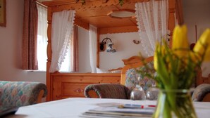 A cozy room with wooden furniture, a bed with a headboard, and a window with curtains.