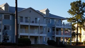A multi-story building with balconies, a dock, and a calm water body. - Updated condo with a fantastic view!



 (Calabash)