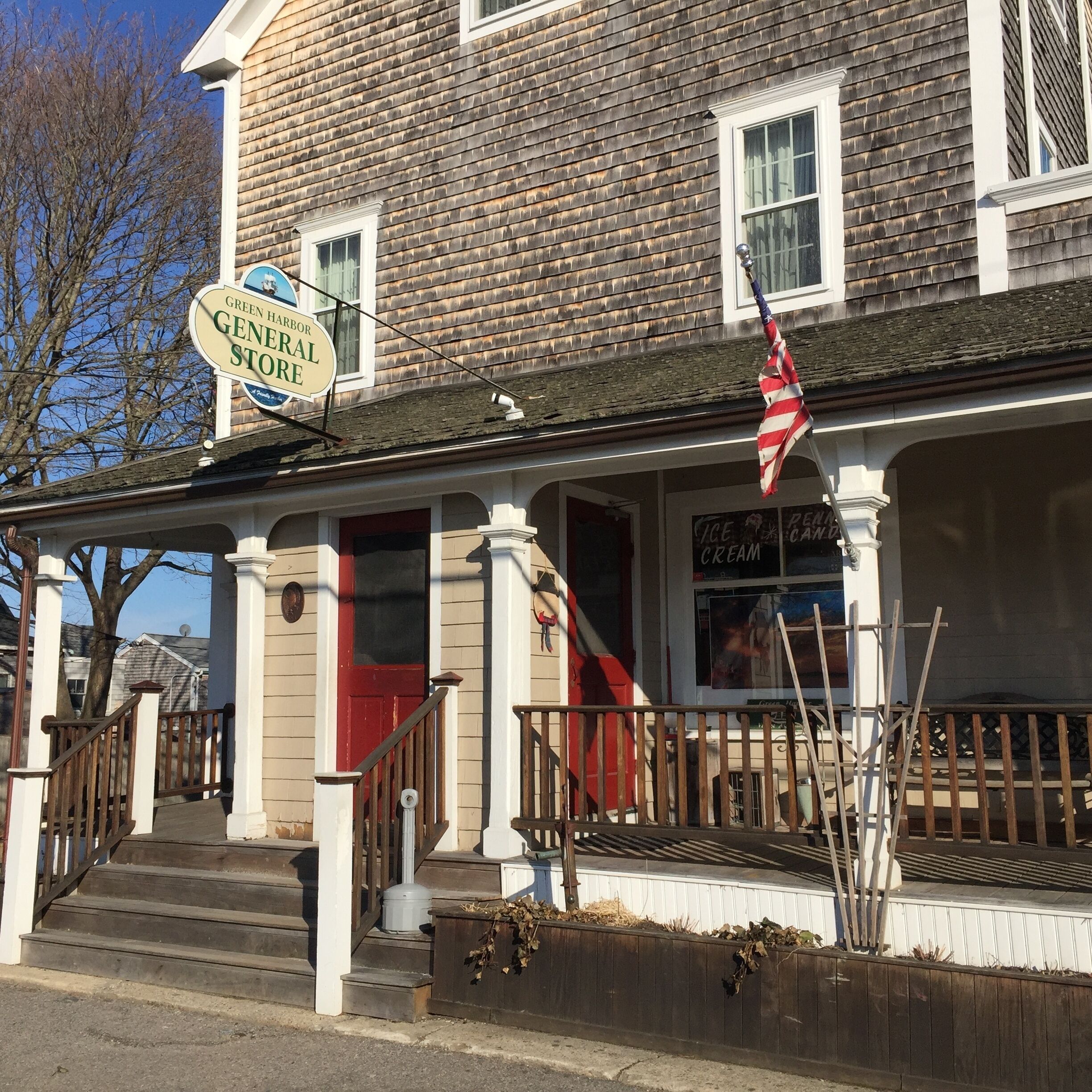 En byggnad med en skylt där det står ”Green Harbor General Store” och en amerikansk flagga.