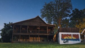 A wooden cabin with a balcony, a mural with the text "NOLIN Lake," and a starry night sky. - OVERSIZED PORCH, LAKE FRONT, Mammoth Cave, Fast WiFi, Firepit, hiking (Mammoth Cave)