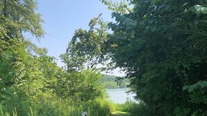 A wooden signpost with a directional arrow labeled "Lake Path" pointing towards a grassy trail leading to a body of water. - OVERSIZED PORCH, LAKE FRONT, Mammoth Cave, Fast WiFi, Firepit, hiking (Mammoth Cave)