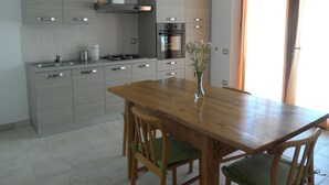Eine moderne Küche mit grauen Schränken, einem Holztisch und einem Blumenstrauß.