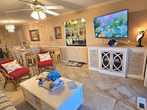 A living room with a dining area, a bar, and a television. - St Simons Island gorgeous MARSHFRONT VIEW, pool, Pond, Near Beach, FLETC (St Simons Island)