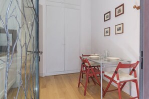 A dining area with a glass table, red chairs, and framed pictures on the wall. - Live at Domus Claudiae, be part of an art work (AirCond-WiFi) (Roma)