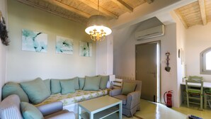 Una sala de estar acogedora con un sofá modular, una mesita y un comedor con una silla.