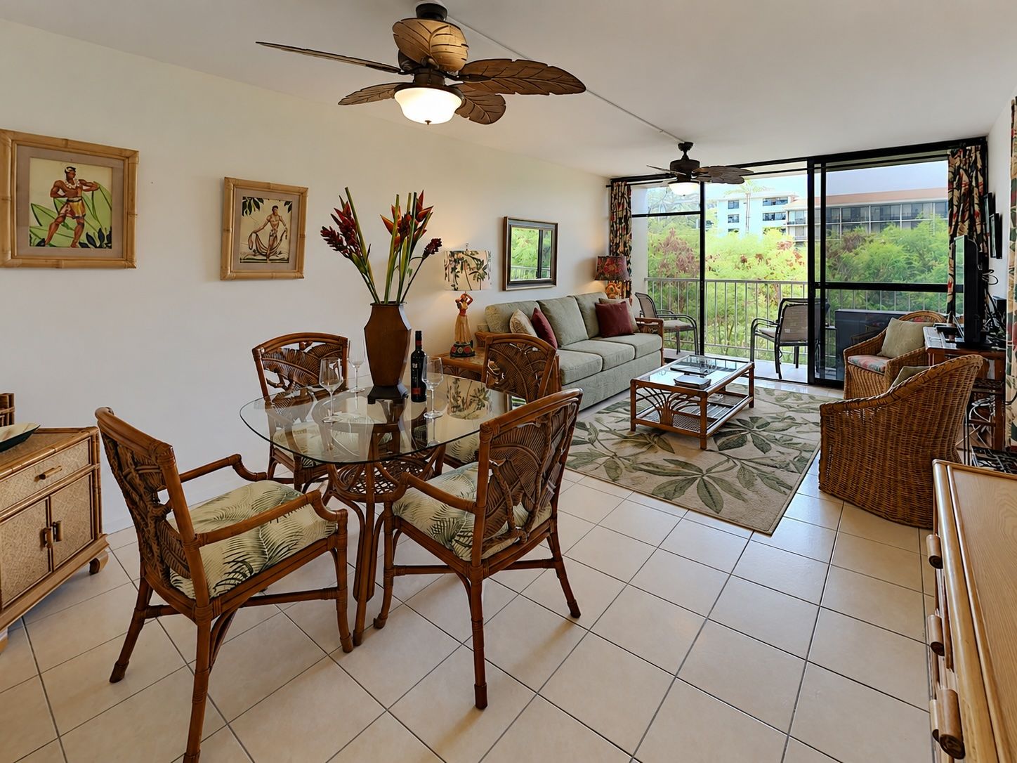 A dining area with a glass table, wicker chairs, and a ceiling fan.
