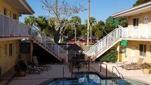 A pool area with a small pool, lounge chairs, and a staircase leading to an upper level. - In the heart of Old Naples (Naples)