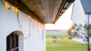 Un bâtiment de style rustique, doté d’un plafond en bois et décoré de guirlandes lumineuses.