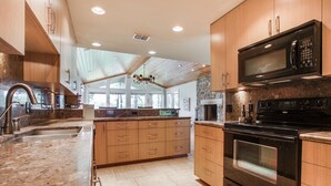 A modern kitchen with wooden cabinets, a stainless steel sink, and a built-in oven.