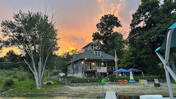 Une propriété au bord du lac comprenant une maison, un quai et un espace extérieur aménagé pour s’asseoir.