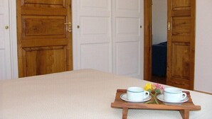 A room with a bed, wooden doors, and a small table with cups and flowers. - great sea view - great position - not far from the town center (Positano)