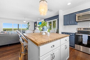 A modern kitchen with a wooden island, white cabinetry, and stainless steel appliances. - Eagle Nest/Your Private Waterfront Escape on Florida's Nature Coast. (Hernando Beach)