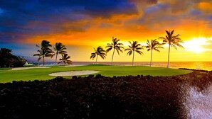 Un parcours de golf bordé de palmiers, offrant une vue imprenable sur le coucher de soleil.