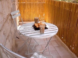 Enjoy a casual breakfast in our outdoor dining area, where a simple table and chair set invites relaxation.