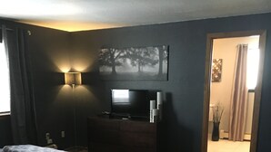 A bedroom with a bed, a dresser, a TV, and a lamp. - Beautifully Renovated South Lake Tahoe Condo  Minutes To Casinos, Ski & Beaches (Zephyr Cove)