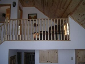 Classic staircase leads to a cozy upper level with a sloped ceiling and wooden beams.