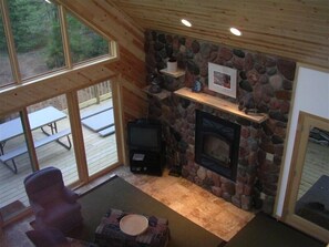 Cozy space with a fireplace, TV, and comfortable seating area, offering a view of the outdoors.