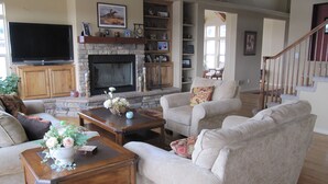 A spacious living room with a fireplace, comfortable seating, and a flat-screen TV. - 6000 sq ft Estate Home on 3 Acres near USAFA in the Rockies (Monument)