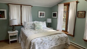 A bedroom with a bed, two bedside tables, a window with curtains, and a skylight. - Glen Lake  - Spectacular Dune Views & Complete Privacy! (Glen Arbor)