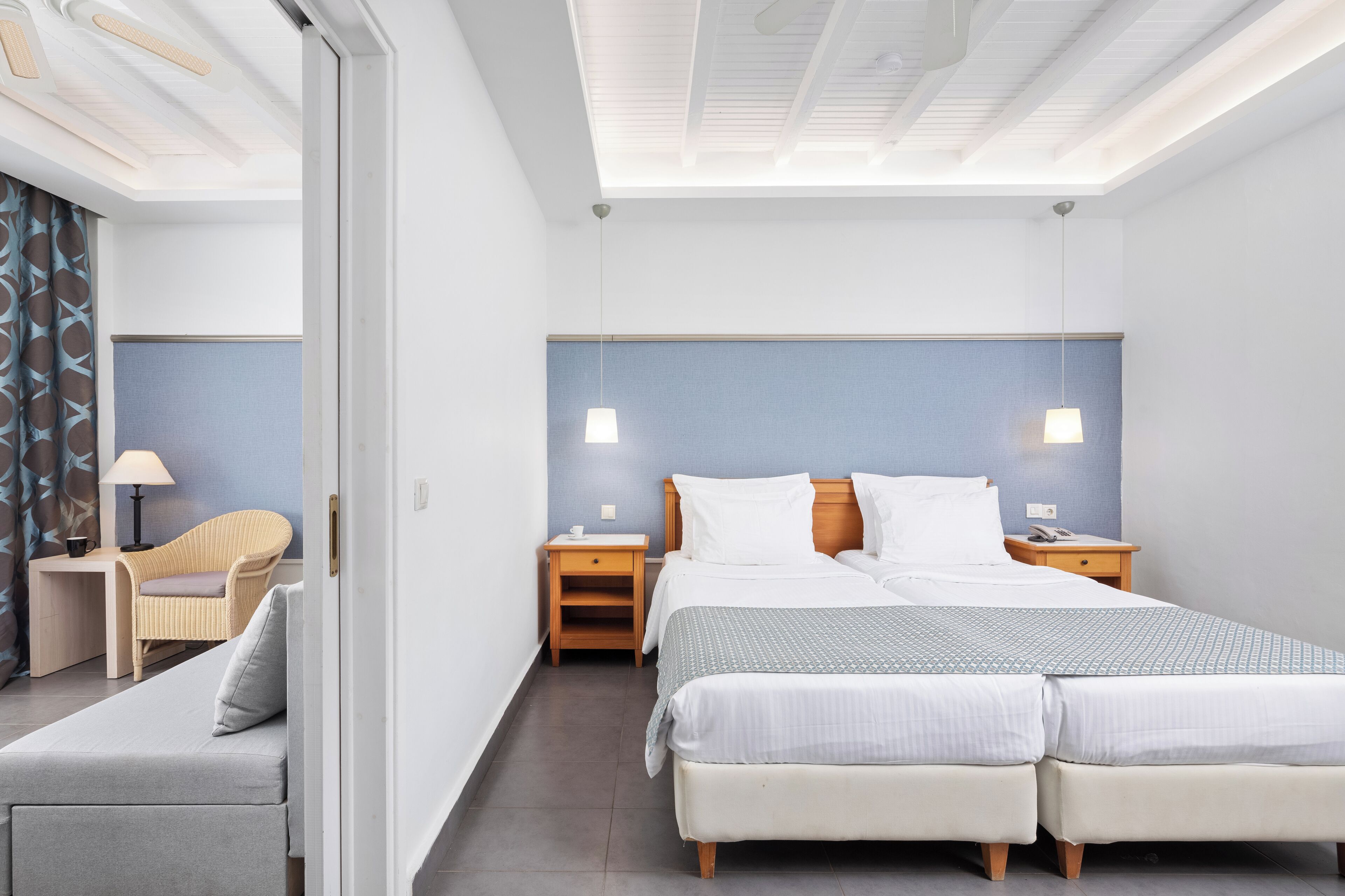 Una habitación de hotel con una cama grande, dos mesitas de noche, una silla y un escritorio.