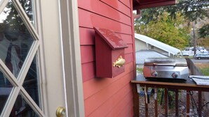 A red exterior wall with a mailbox and a grill on a balcony. - MontanAloha, a hideaway just North of Downtown Missoula (Missoula)