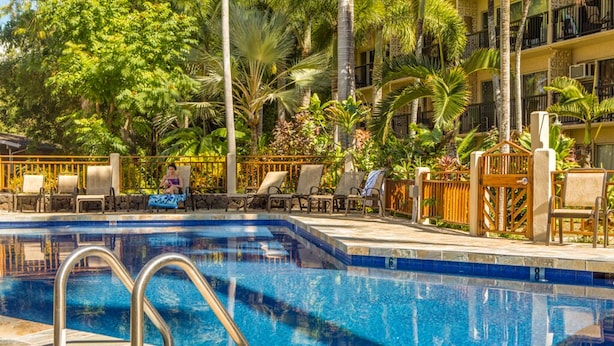 Uma piscina com espreguiçadeiras e um deck de pedra.