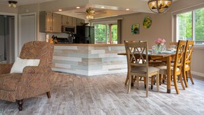 A spacious kitchen with a central island, wooden dining table, and chairs. - The Round House at Pleasant Hill, Near Mohican & Snow Trails (Perrysville)
