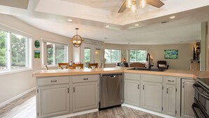 A spacious kitchen with grey cabinets, a dishwasher, and a large island. - The Round House at Pleasant Hill, Near Mohican & Snow Trails (Perrysville)