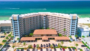 Ein großes Hotel mit mehreren Etagen und Balkonen, direkt am Strand mit Blick auf den Ozean.