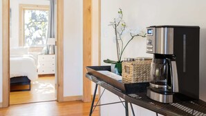 A modern kitchen with a coffee machine, a woven basket, and a potted orchid. - Modern, Quality 4BR Near Downtown (Durham)