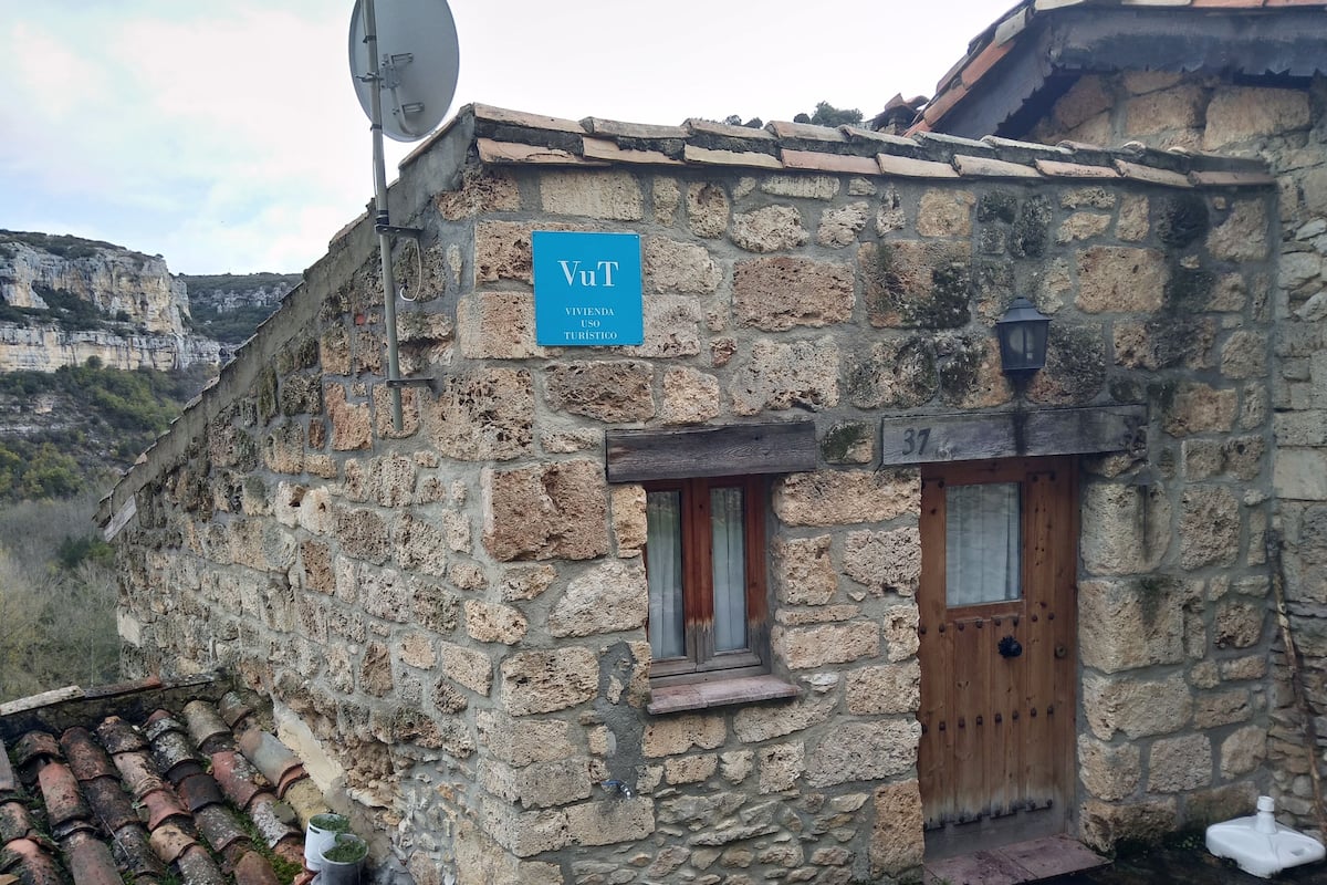 A stone building with a sign indicating it is a tourist accommodation.
