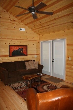 Cozy log-furnished space with a leather sofa, armchair, and wooden coffee table.