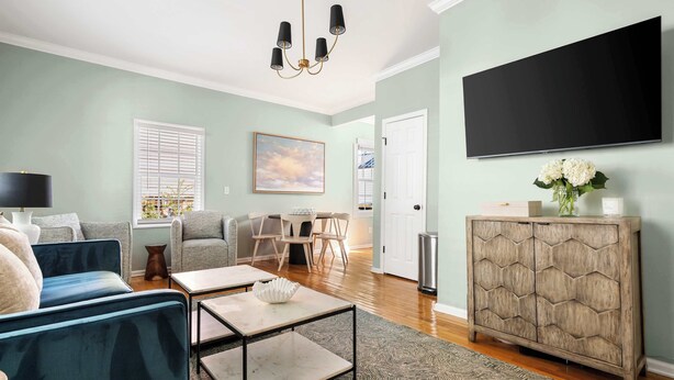 A living room with a sofa, coffee table, TV, and a cabinet.