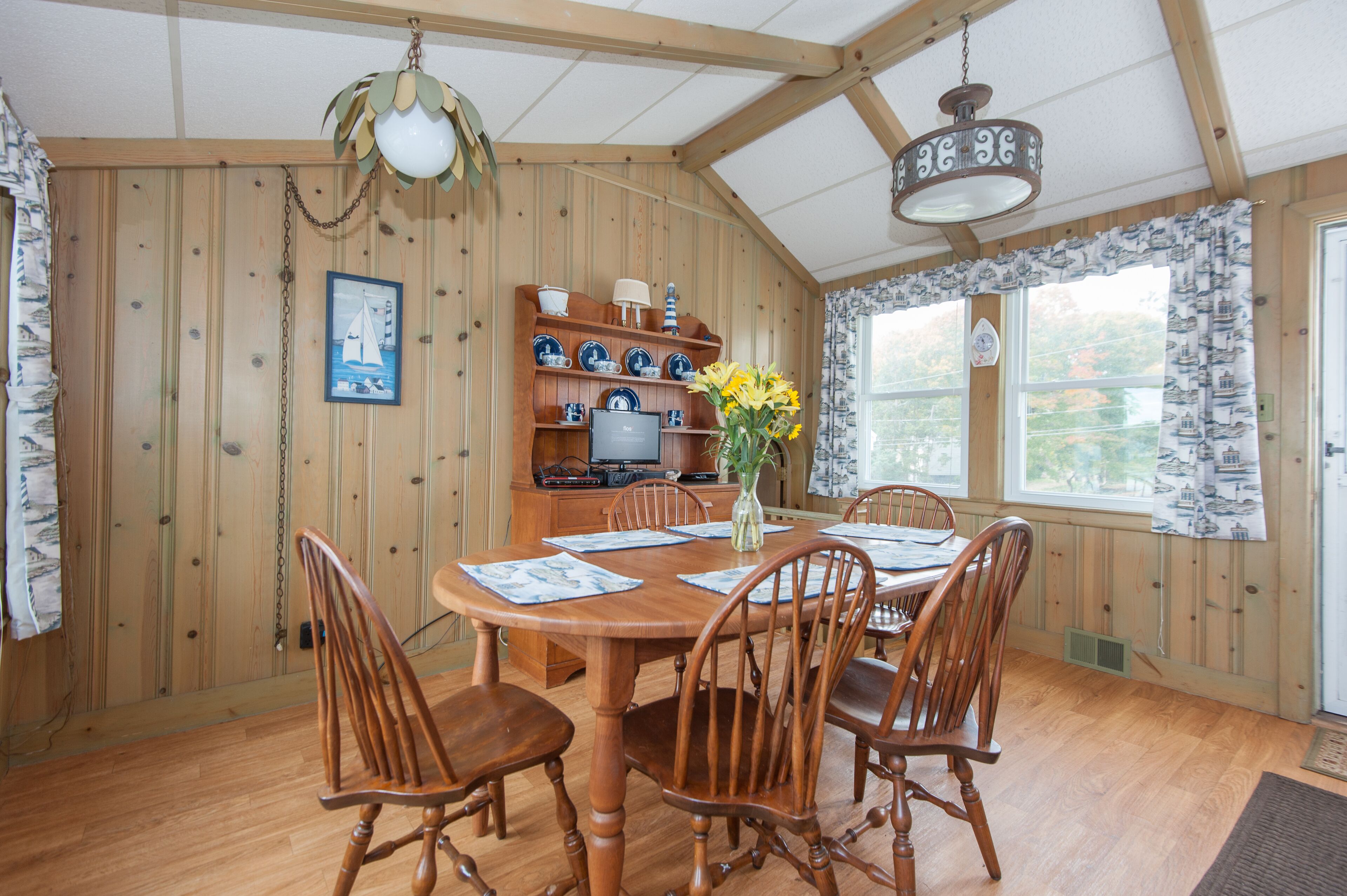 Una habitación con paneles de madera y una mesa de comedor para cuatro personas, rodeada de sillas.