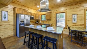 Ein Holzblockhaus-Interieur mit Küche, Barbereich und Essbereich.
