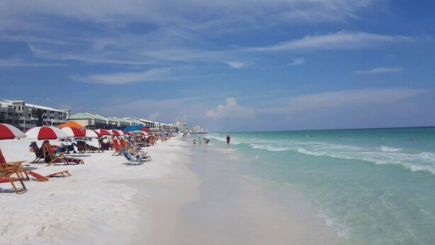 A beach with rows of beach chairs and umbrellas, a sandy shore, and a clear blue sky. - Recently-Remodeled Destin Townhouse. Extended Stay Discount Nov-Feb (Miramar Beach)