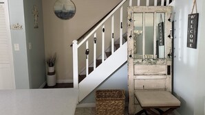 A staircase with a white railing, a mirror, a welcome sign, and a wall-mounted circular decoration. - Recently-Remodeled Destin Townhouse. Extended Stay Discount Nov-Feb (Miramar Beach)