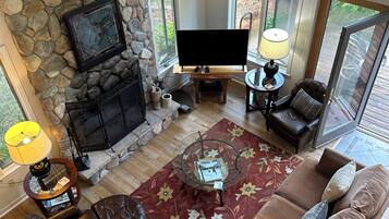 Télévision, cheminée, lecteur de DVD, livres