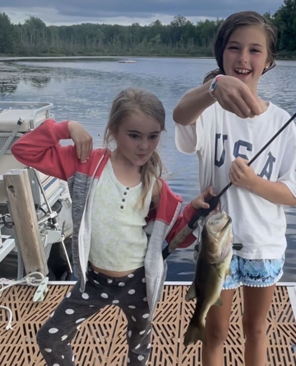 Deux personnes dans un bateau, tenant un poisson.