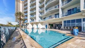 Una piscina con indicador de profundidad de 3 pies, rodeada por un suelo de baldosas y una cerca metálica.