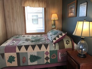 Ein Zimmer mit Bett, Lampe, Fenster und einer Willkommensschild.